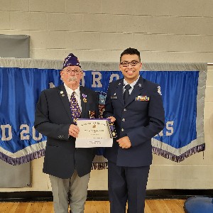 ROTC leader and student holding student's award certificate